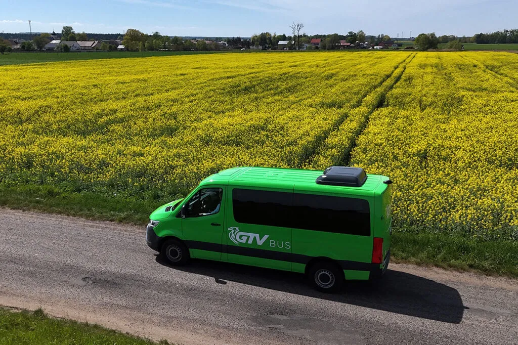 Zielony bus na tle rzepaku