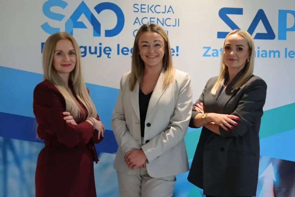 Pracownicy na pozujący na ściance